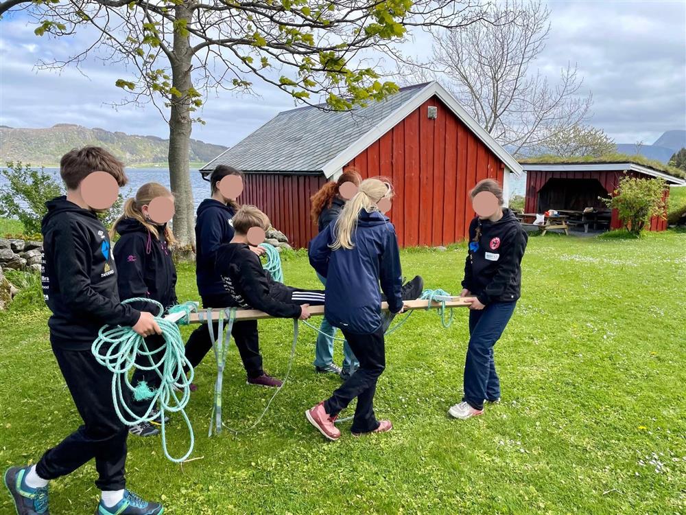 Ungdommar ber ein person på båre - Klikk for stort bilete